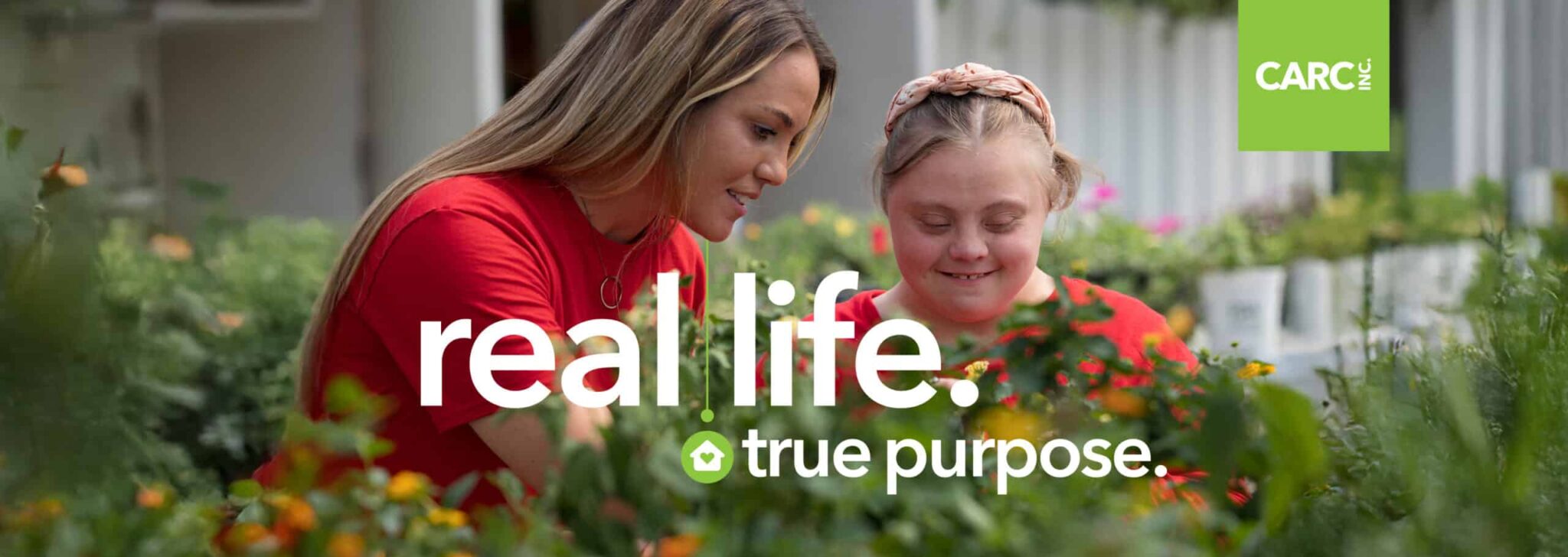 A CARC employee assisting a CARC resident in the greenhouse.